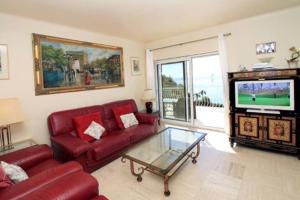 een woonkamer met een rode bank en een tv bij Villa piscine Eze bord de mer à 500m de la plage in Èze