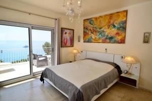 a bedroom with a bed and a large window at Villa piscine Eze bord de mer à 500m de la plage in Èze +23 photos