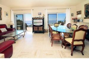 a living room with a glass table and a television at Villa piscine Eze bord de mer à 500m de la plage in Èze