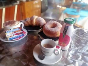 un tavolo con caffè, ciambelle e tazze di caffè di B&B Mediterraneo a Cetraro