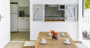 a kitchen with a wooden table and a kitchen with white cabinets at Dream Villa Lorient 659 in Saint Barthelemy