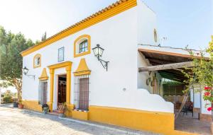 ein weißes Gebäude mit gelbem Trimm und einer Straße in der Unterkunft Beautiful Home In Los Palacios With Private Swimming Pool, Can Be Inside Or Outside in Los Palacios y Villafranca