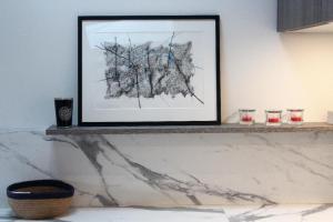 a picture on a shelf with two glasses on it at Burdigala Homes - Appart rue Minvielle in Bordeaux