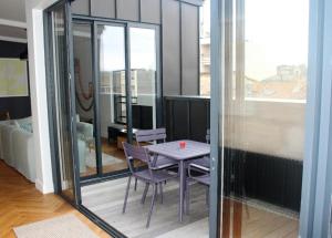 a purple table and chairs in a room with a window at Burdigala Homes - Appart rue Minvielle in Bordeaux