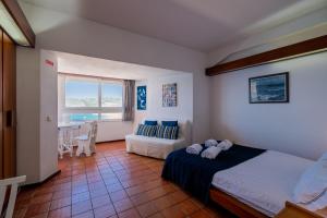 セジンブラにあるRent4rest - Sesimbra Ocean View Studioのベッドルーム1室(ベッド1台、ソファ、窓付)