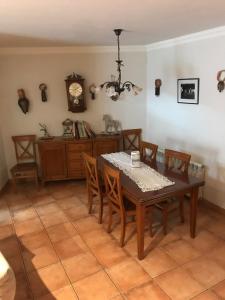 una sala da pranzo con tavolo, sedie e orologio di Corral de Jaume a Ager