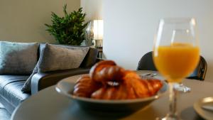 un tazón de donuts y un vaso de zumo de naranja en una mesa en Flat 3 Castle Street Serviced Apartments, en Telford