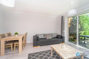 a living room with a couch and a table at Apartment for 10 with garden and parking in Gdańsk