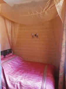 a small bedroom with a bed in a tent at En pleine nature in Bonneuil-en-Valois