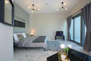 a bedroom with a bed and a large window at SHH - Furnished Studio in Dubai South Near to Expo 2021 in Dubai