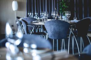 Fjordgaarden - Kurbad - Hotel - Konference في رينكوبنج: صف من الطاولات والكراسي عليها كؤوس النبيذ