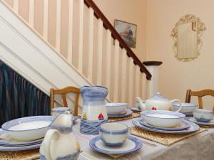 a table with plates and bowls and a vase on it at Hill View in Swanage