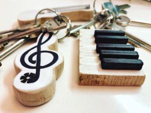 a pair of keys and a wooden keyboard with a keychain at Musicisti House in Verona