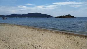 a beach with a small island in the water at Celia`s Studio in Nea Peramos