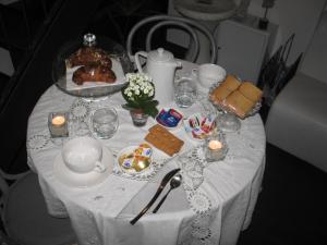 a table with a white table cloth with food and candles at B&B Il Rustico in Turate