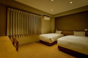 um quarto de hotel com duas camas e uma janela em ikoi HOTEL em Quioto