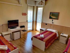a hotel room with two beds and a television at Affittacamere Metro Fiera in Pero