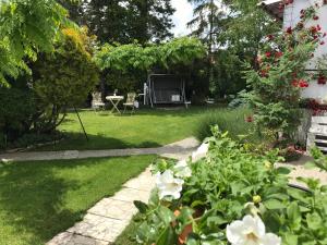 einen Garten mit einem Tisch, Stühlen und Blumen in der Unterkunft Relaxační studio VERA s UBYTOVÁNÍM in Valtice