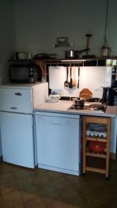 a kitchen with a white refrigerator and a stove at La Clôture in Lanouée