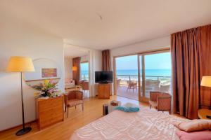 シルヴィ・マリーナにあるGrand Hotel Bertiのベッド付きのホテルルームで、海の景色を望めます。