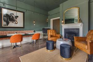 a living room with a table and chairs and a fireplace at Blakeney House in Blakeney
