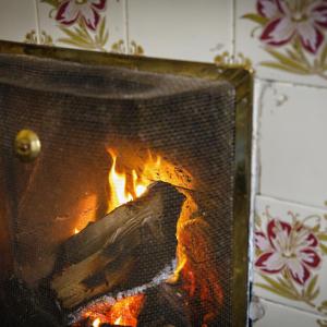 a fire burns inside of a fireplace at Blakeney House in Blakeney