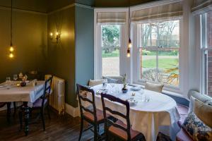 a dining room with two tables and a window at Blakeney House in Blakeney