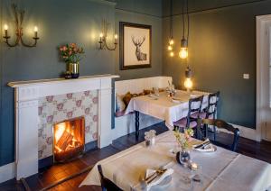 a dining room with two tables and a fireplace at Blakeney House in Blakeney