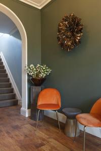 a room with two chairs and a vase on the wall at Blakeney House in Blakeney