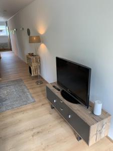 a living room with a large flat screen tv at daheim im hirschen in Schönwald