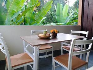 een tafel met stoelen en een fruitschaal erop bij Khrisna Hs and Cottages in Sidemen