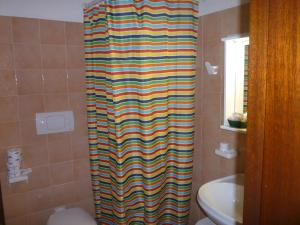 a colorful shower curtain in a bathroom with a toilet at Hotel L'Ancora in Santa Teresa Gallura