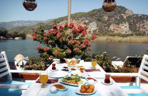 a table with food and a view of the water at Myra Hotel in Dalyan