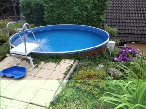 a swimming pool with a chair in a yard at Ubytování na Šumavě in Sušice