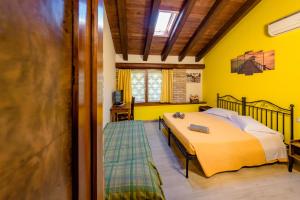 a bedroom with a bed and a yellow wall at Isola Di Wight in San Michele al Tagliamento