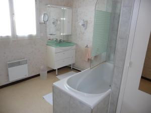 a white bathroom with a tub and a sink at Hotel du Haut Marais in Saint-Marcel