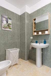 een badkamer met een wastafel, een spiegel en een toilet bij Home2Book Charming Apartment Candelaria, Wifi & Pool in Candelaria