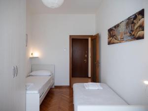 The Best Rent - Modern two bedroom apartment in Milan في ميلانو: غرفة صغيرة بسريرين وباب
