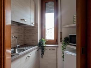 The Best Rent - Modern two bedroom apartment in Milan في ميلانو: مطبخ بخزائن بيضاء ومغسلة ونافذة