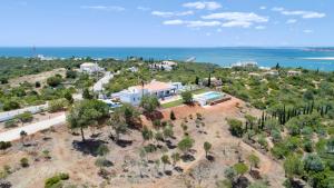 een luchtzicht op een huis op een heuvel naast de oceaan bij Luxury Villa, Ocean View, Private Heated Pool in Ferragudo