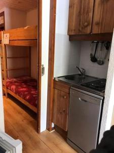a small kitchen with a stove and a bunk bed at Studio 50 m du funiculaire et pistes in Tignes