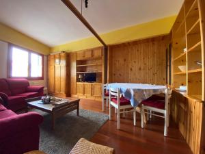 a living room with a table and a couch at Appartamento Superior Condominio Orso Bianco, parquet, Wi-Fi in Prati di Tivo