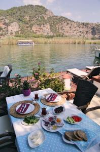 a table with food on it next to a body of water at Myra Hotel in Dalyan