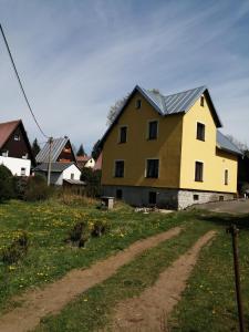 a yellow house with a grey roof on a field at U Petíse in Horní Blatná