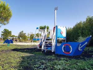 a playground with a slide in a park at Camping Paradis 4 étoiles Au Port de L'Houmeau - La Rochelle in LʼHoumeau