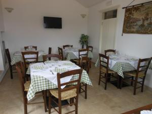 a dining room with tables and chairs and a television at Agriturismo Masseria Casedde Vecchie in Martina Franca