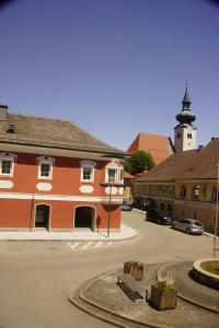 un grande edificio rosso con una torre dell'orologio in un parcheggio di Vintage 2 Ferienwohnung für 2-3-4 a Schörfling am Attersee