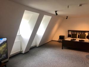 Schlafzimmer mit weißen Wänden, einem Bett und einem TV in der Unterkunft Ramer Tower apartment in Old Town in Riga