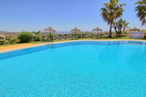 une grande piscine bleue dans un complexe dans l'établissement CT 182 - Golfer's Paradise, à Mijas