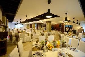 une salle à manger avec des tables et des chaises blanches dans l'établissement Complex HAMAK, à Iaşi